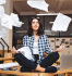 Mulher desenvolvendo inteligncia emocional no trabalho, sentada na mesa de um escritrio meditando enquanto folhas de papel caem.