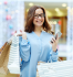 Mulher feliz segurando sacolas de compras em um shopping aps a aplicao da estratgia de como fidelizar clientes.